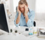 sick caucasian man sitting office squeezing temples because headache working computer looking screen with painful expression face trying concentrate surrounded by medicine 90x80